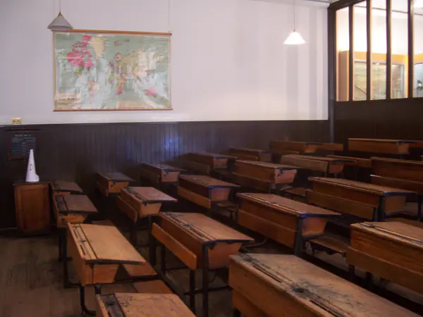Aula antigua con pupitres de madera en filas