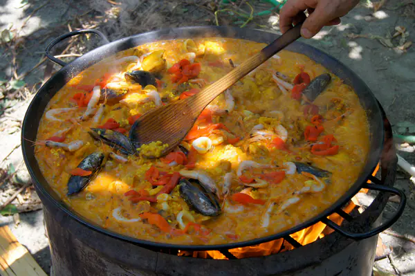 Paella de marisco cocinándose a la leña